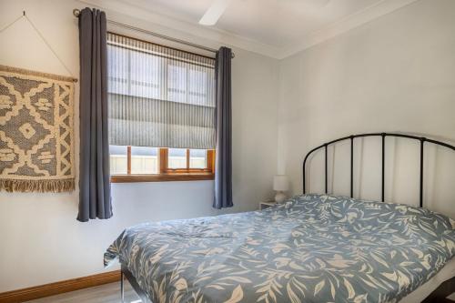 a bedroom with a bed and a window at Swan Lake Escape in Sussex inlet