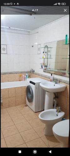 uma casa de banho com uma máquina de lavar roupa e um lavatório em Sweet Home Center City em Chisinau