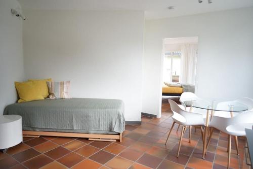 um quarto com uma cama, uma mesa e cadeiras em Gartenwohnung vor den Toren Berns em Zollikofen