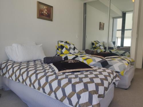 1 dormitorio con 2 camas con almohadas en Spacious1 BR@waterfront Olympic Park_free carpark, en Sídney