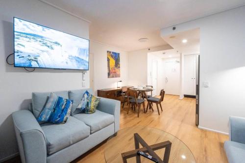 ein Wohnzimmer mit einem Sofa und einem Tisch in der Unterkunft Story Bridge & River View 2B1B Apt w Free Parking! in Brisbane