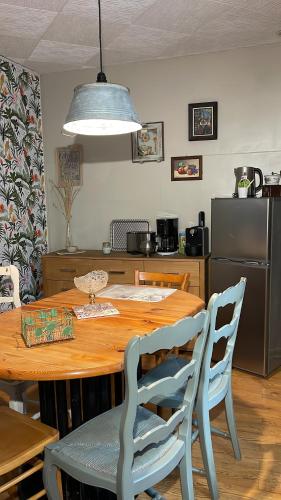 cocina con mesa de madera con sillas y comedor en appartement Vintage a l ancienne forge en Muhlbach-sur-Munster