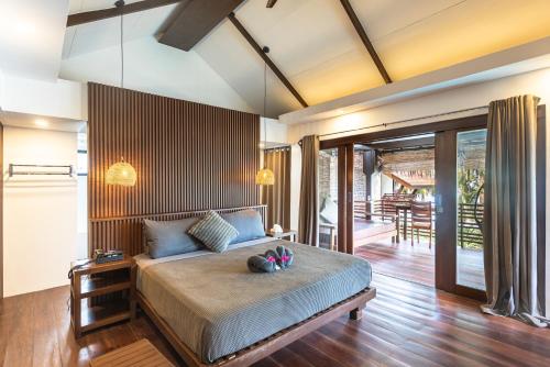 a bedroom with a large bed and a patio at Siargao Island Villas in General Luna