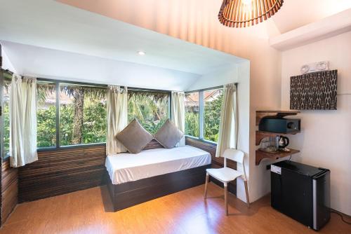 a bedroom with a bed and a window at Siargao Island Villas in General Luna