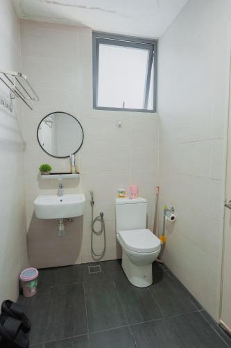 a bathroom with a toilet and a sink and a mirror at AAIRA Troika Residence,Kota Bharu in Kota Bharu