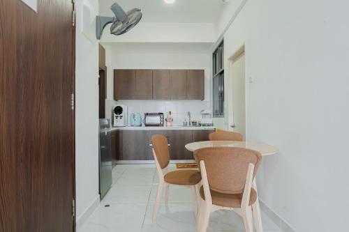 a kitchen with a table and chairs in a room at AAIRA Troika Residence,Kota Bharu in Kota Bharu
