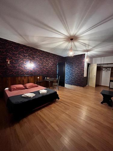 une chambre avec un lit et une table dedans dans l'établissement Relais de la tour, à Termes-dʼArmagnac