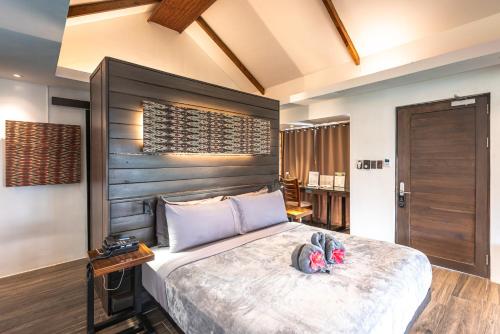 a bedroom with a large bed with a wooden headboard at Siargao Island Villas in General Luna