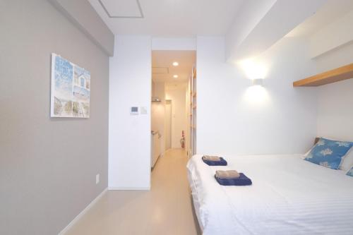 una camera bianca con un letto in una stanza di Good Life Apartment - Vacation STAY 08485v a Naha