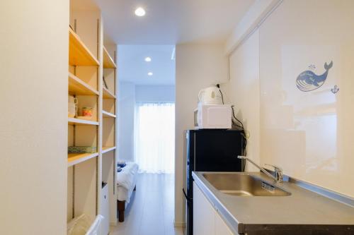 una cucina con lavandino e frigorifero di Good Life Apartment - Vacation STAY 08485v a Naha
