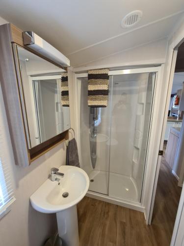 a bathroom with a sink and a shower at 6 St Andrews- Craig Tara in Ayr