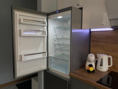 einen Kühlschrank mit offener Tür in der Küche in der Unterkunft Rezekne Lux Apartments in Rēzekne