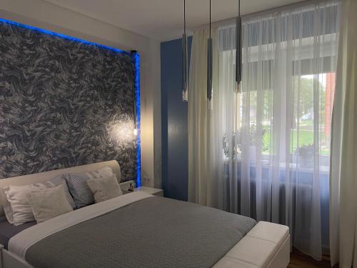 a bedroom with a bed and a large window at Rezekne Lux Apartments in Rēzekne
