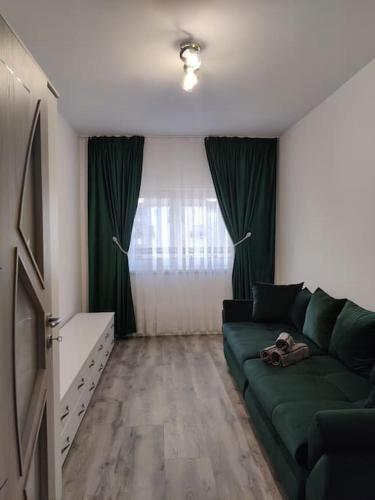 a living room with a green couch in front of a window at FLH - AntHome in Sibiu