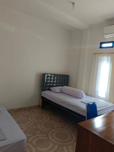 una piccola camera con letto e finestra di Sibento Komodo Homestay a Labuan Bajo