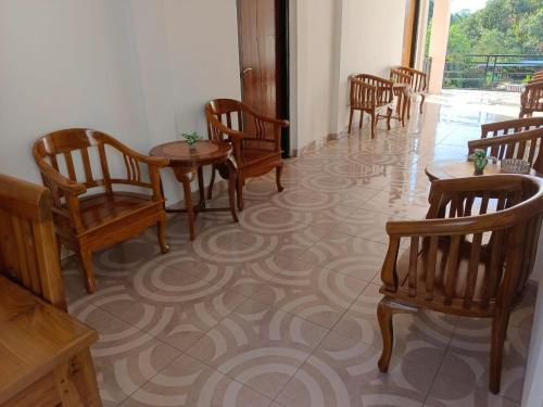 a row of chairs and tables in a room at Sibento Komodo Homestay in Labuan Bajo