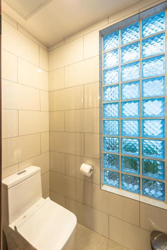 a bathroom with a toilet and a window at Siargao Island Villas in General Luna
