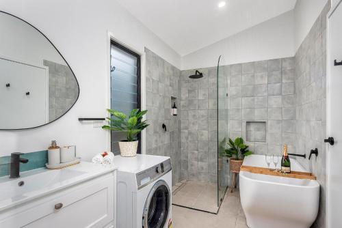 uma casa de banho com um chuveiro, um lavatório e uma máquina de lavar roupa em Sheket em Gold Coast
