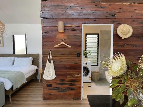 una camera da letto con un letto e una parete con accenti in legno di Sheket a Gold Coast