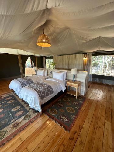a bedroom with a bed in a tent at Olesamara Collection in Nanyuki