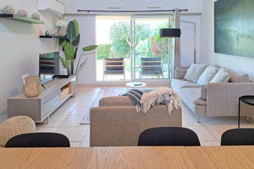 un salon avec un canapé et une table dans l'établissement 110m Villa Cannes with Swimming Pools AC and Garage - BENAKEY, à Cannes