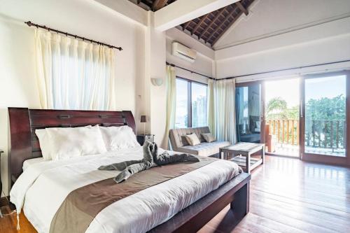 um quarto com uma cama grande e uma varanda em Villa Kenanga in Meninting By The Beach em Mataram