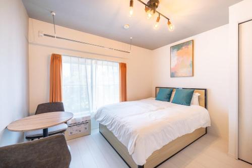 a bedroom with a bed and a table and a window at Laluna Higashiikebukuro in Tokyo