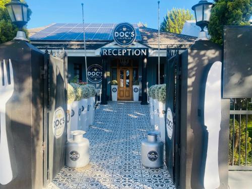 una puerta que conduce a un restaurante para perros con dos contenedores azules en Halfway House Hotel, en Kimberley