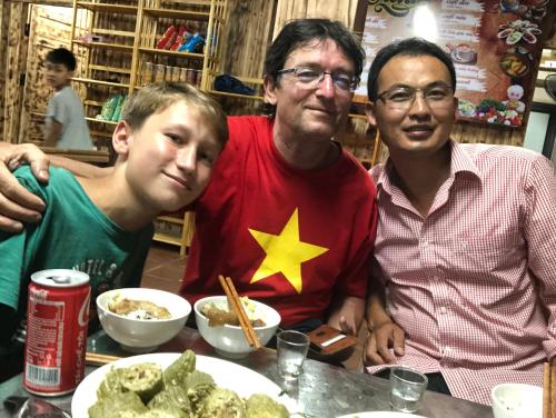 eine Gruppe von drei Personen, die an einem Tisch mit Essen sitzen in der Unterkunft Homestay Huyền Thoại Cao Nguyên Đá 