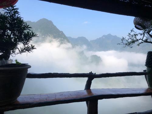 a window with a view of the water and mountains at Homestay Huyền Thoại Cao Nguyên Đá in Lao Ou Tchai