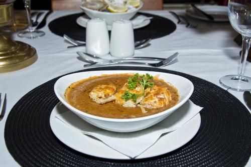 a bowl of soup sitting on a plate on a table at Bahnhof Hotel Aus in Aus