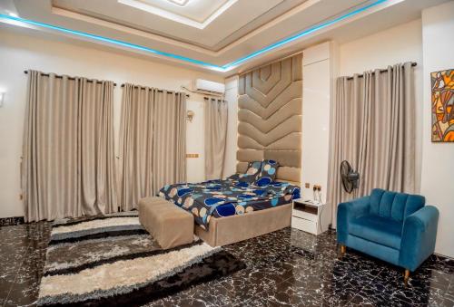 a bedroom with a bed and a blue chair at Luxury 4 bedroom duplex in Lekki