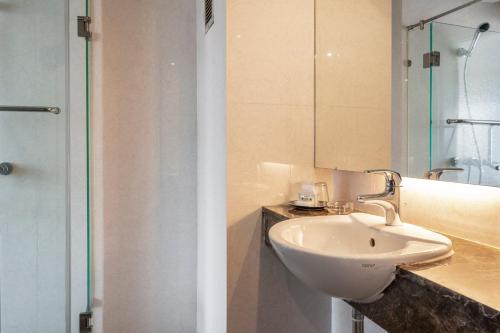 a bathroom with a sink and a mirror at Welcome Plaza Hotel Pattaya in Pattaya Central
