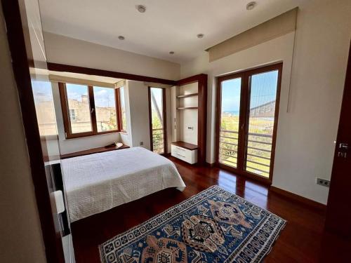 1 dormitorio con cama y ventanas con vistas en Lux villla near cntr with view pool beach accss, en Sarıyer