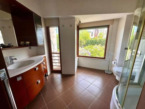 a bathroom with a sink and a toilet and a window at Lux villla near cntr with view pool beach accss in Sarıyer