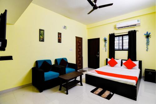 a bedroom with a bed and two chairs in it at OYO Flagship Sri Balaji Guest House in Bhubaneshwar