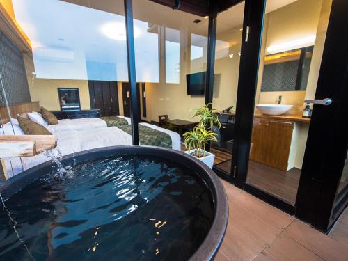 a large bath tub in a room with a living room at LiVEMAX RESORT Kinugawa in Nikko