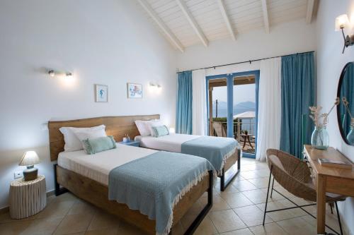 a hotel room with two beds and a balcony at Ionian Calm Villas in Vasiliki