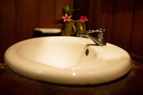 La salle de bains est pourvue d'un lavabo blanc et d'un robinet. dans l'établissement Mekong Bird Resort & Hotel, à Stœ̆ng Trêng
