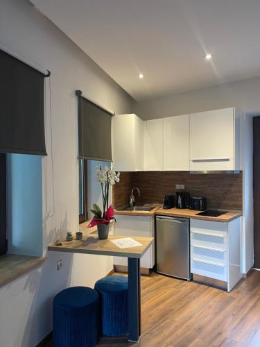 a kitchen with a table and two blue stools at 11 Luxury apartments. in Metsovo