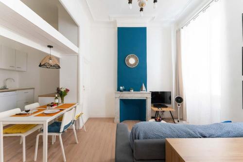 un salon avec un mur bleu et une table dans l'établissement Escapade marseillaise près des Terrasses du Port, à Marseille