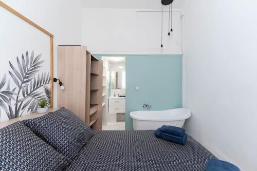 une chambre avec un lit et une salle de bain avec baignoire dans l'établissement Escapade marseillaise près des Terrasses du Port, à Marseille