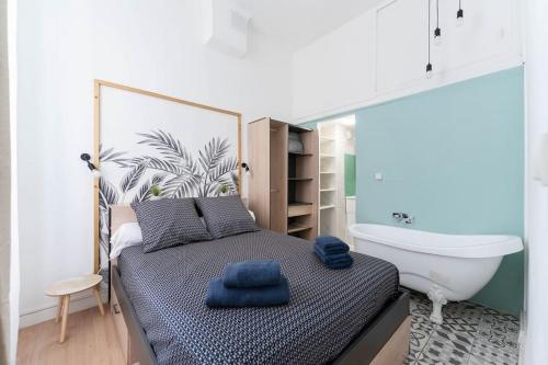 une chambre avec un lit et une baignoire dans l'établissement Escapade marseillaise près des Terrasses du Port, à Marseille