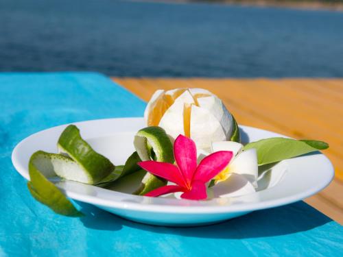 a plate of food with a flower on a table at Mekong Bird Resort & Hotel in Stœ̆ng Trêng