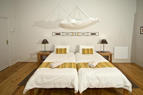 two beds in a white room with two lamps at Bahnhof Hotel Aus in Aus