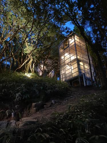 a building on top of a hill at night at ThinkStay Mt.(シンクステイ・マウンテン) in Mikagechō