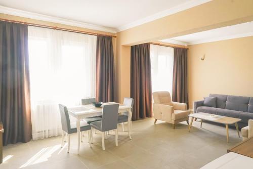 Kumru Suites في Sarıcaeli: غرفة معيشة مع طاولة وكراسي وأريكة