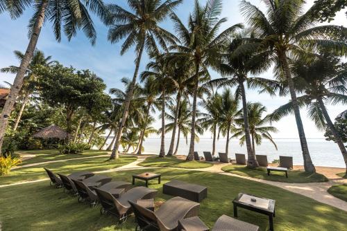 a row of chairs and tables in front of the beach at Siargao Island Villas in General Luna