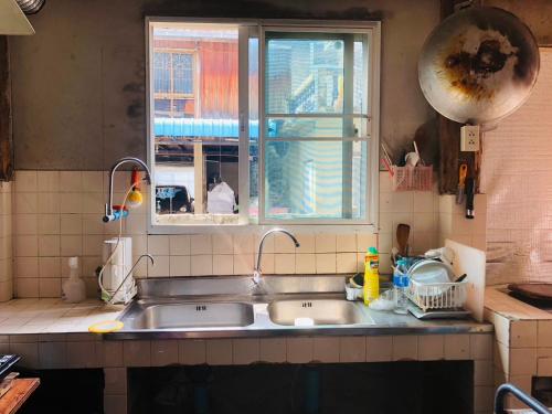 a kitchen sink with two faucets and a window at SolarCell walking street Homestay - โซล่าเซลล์ถนนคนเดินโฮมสเตย์ in Ban Nong Nam Khan