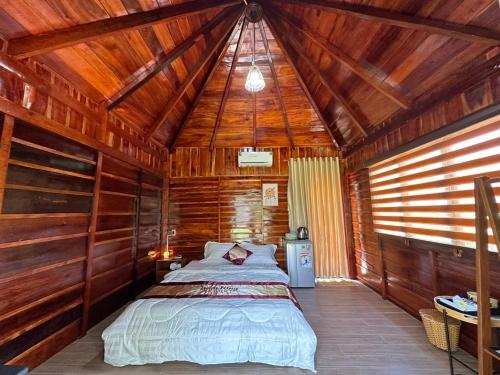 a bedroom with a bed in a wooden cabin at Bum King Resort Hồ Tràm in Xuyên Mộc